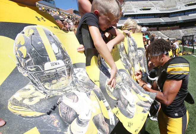Iowa receiver Seth Anderson signs autographs for fans during Kids' Day at Kinnick Stadium on Saturday, Aug. 12, 2023, in Iowa City, Iowa.