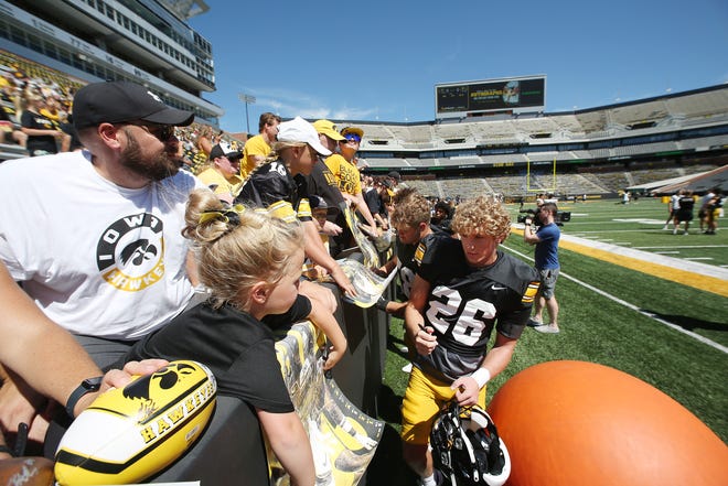Iowa football team members sign autographs for fans during Kids' Day at Kinnick Stadium on Saturday, Aug. 12, 2023, in Iowa City, Iowa.
