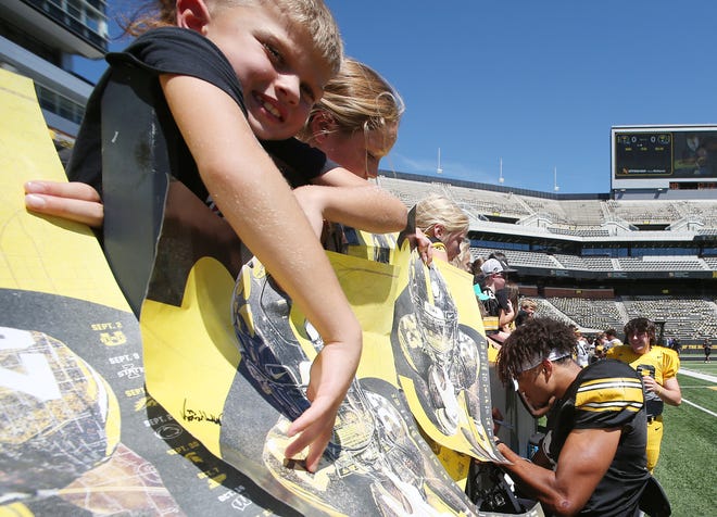 Iowa football team members sign autographs for fans during Kids' Day at Kinnick Stadium on Saturday, Aug. 12, 2023, in Iowa City, Iowa