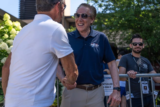 Republican Businessman Perry Johnson talks with a fairgoer before speaking on the Des Moines Register Political soapbox on Friday, Aug. 11, 2023, at the Iowa State Fair, in Des Moines.