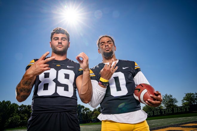 Connecticut natives Nico Ragaini (#89) and Diante Vines (#0) hold up their 203 area code as they stand for a photo during Hawkeyes Football media day in Iowa City, Friday, Aug. 11, 2023.