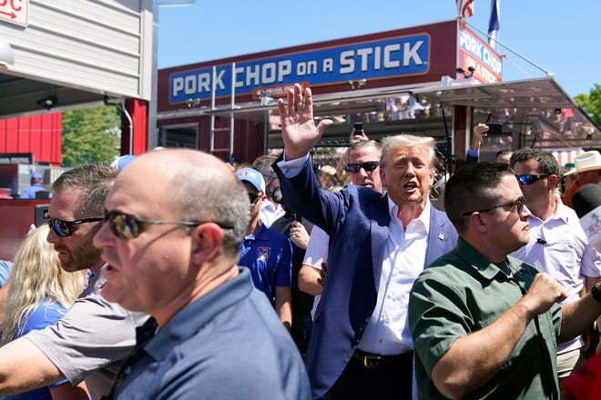 Republican presidential candidate former President Donald Trump waves to supporters at the Iowa Pork Producers tent during a visit to the Iowa State Fair, Saturday, Aug. 12, 2023, in Des Moines, Iowa. (AP Photo/Charlie Neibergall)