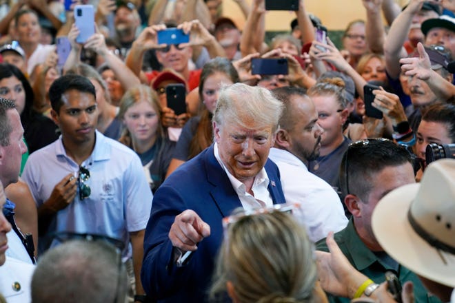 Republican presidential candidate former President Donald Trump reacts as he greets supporters during a visit to the Iowa State Fair, Saturday, Aug. 12, 2023, in Des Moines, Iowa. (AP Photo/Charlie Neibergall)