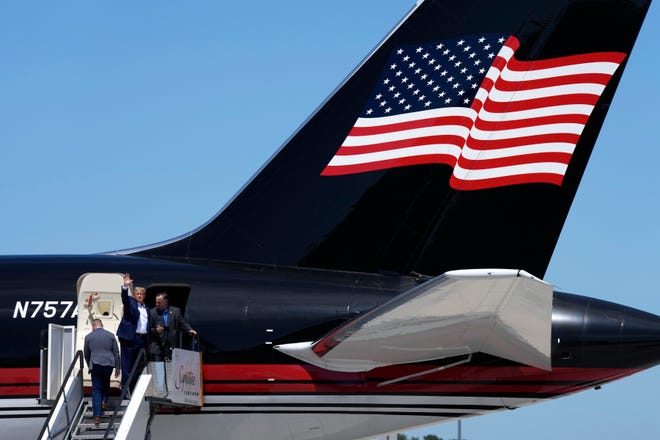 Republican presidential candidate former President Donald Trump waves to supporters as he boards his plane after a visit to the Iowa State Fair, Saturday, Aug. 12, 2023, in Des Moines, Iowa. (AP Photo/Charlie Neibergall)