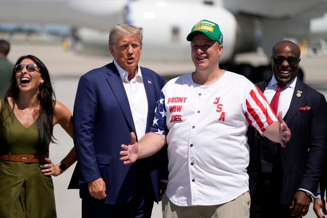 Republican presidential candidate former President Donald Trump greets Travis Klinefelter, of Dubuque, Iowa, at the Des Moines International Airport after a visit to the Iowa State Fair, Saturday, Aug. 12, 2023, in Des Moines, Iowa. (AP Photo/Charlie Neibergall)
