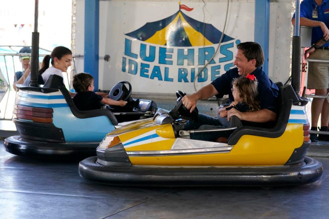 Republican presidential candidate Florida Gov. Ron DeSantis laughs as he drives a bumper car with his daughter Madison as they hit another car driven by Casey DeSantis, left, and their son Mason at the Iowa State Fair, Saturday, Aug. 12, 2023, in Des Moines, Iowa. (AP Photo/Jeff Roberson)