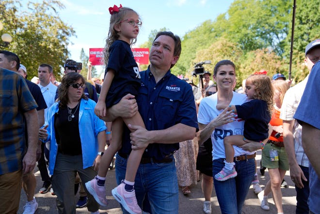 Republican presidential candidate Florida Gov. Ron DeSantis holds his daughter Madison as he walks alongside his wife Casey DeSantis, right, holding their daughter Mamie at the Iowa State Fair, Saturday, Aug. 12, 2023, in Des Moines, Iowa. (AP Photo/Jeff Roberson)
