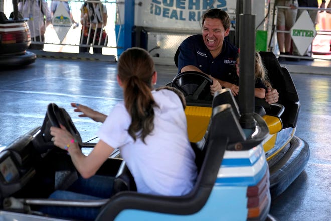 Republican presidential candidate Florida Gov. Ron DeSantis laughs as he hits a bumper car driven by his wife Casey DeSantis at the Iowa State Fair, Saturday, Aug. 12, 2023, in Des Moines, Iowa. (AP Photo/Jeff Roberson)