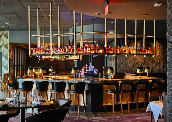 The second-floor bar features backlit bottles overhead and 25 seats at Ruth's Chris Steak House in West Des Moines. The 15,000-square-foot restaurant opens on Aug. 14, 2023.