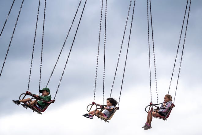 Fairgoers ride the Yo Yo at the Iowa State Fair's Thrill Town, on Monday, Aug. 14, 2023, in Des Moines.
