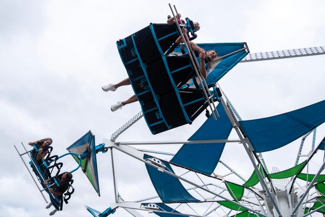 Fairgoers soar above the Iowa State Fair on a Thrill Town ride, on Monday, Aug. 14, 2023, in Des Moines.