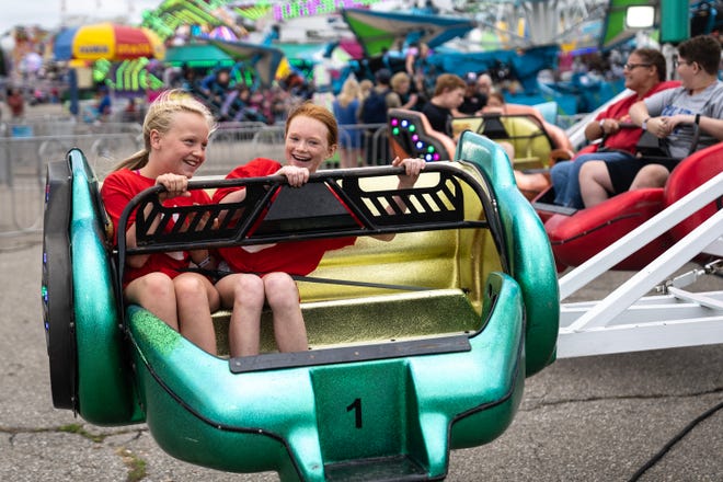 Isabell Downs, of Union, and Nichole Harriman, of Tama, spin in circles on a ride at the Iowa State Fair midway, Thrill Town, on Monday, Aug. 14, 2023, in Des Moines.