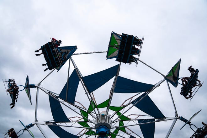 Fairgoers soar above the Iowa State Fair on a Thrill Town ride, on Monday, Aug. 14, 2023, in Des Moines.