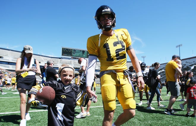 Iowa quarterback Cade McNamara (12) walks with kid captains at Kinnick Stadium during the Kids' Day at Kinnick annual event on Saturday, Aug. 12, 2023, in Iowa City, Iowa