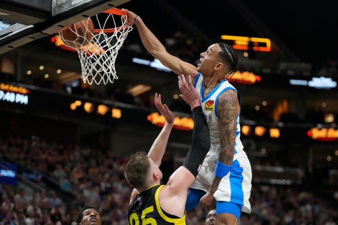 Oklahoma City Thunder's Tre Mann (23) dunks against Utah Jazz center Micah Potter (25) in the first half during an NBA Summer League basketball game Monday, July 3, 2023, in Salt Lake City.