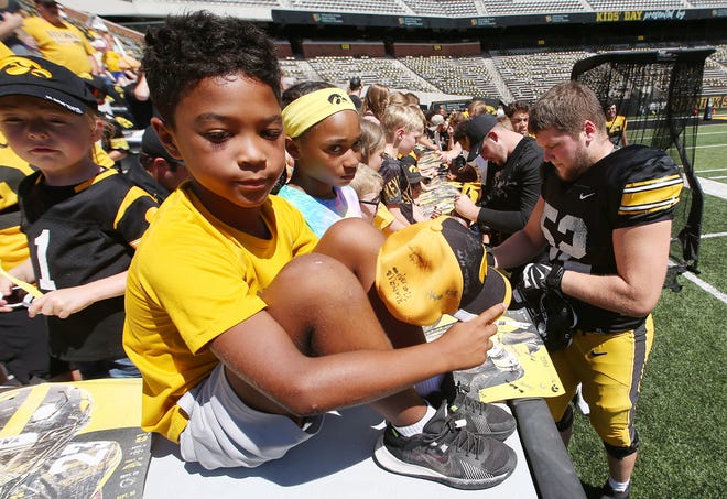 Iowa football team members sign autographs for fans during Kids' Day at Kinnick at Kinnick Stadium on Saturday, Aug. 12, 2023, in Iowa City, Iowa.